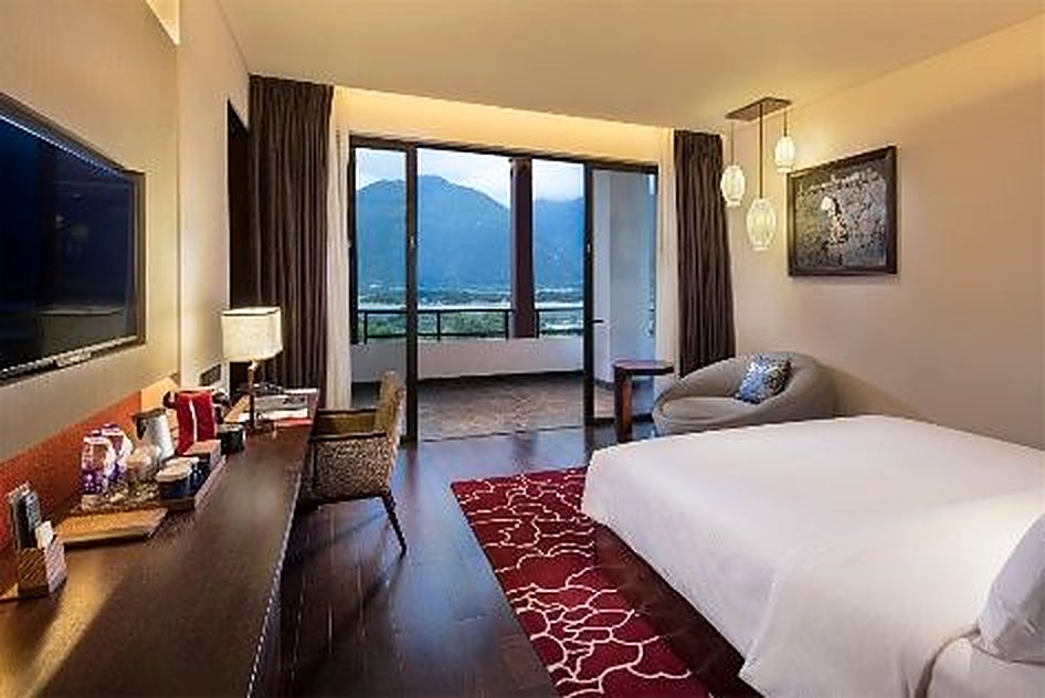 Aerial view of Hilton Linzhi Resort with river and mountains
