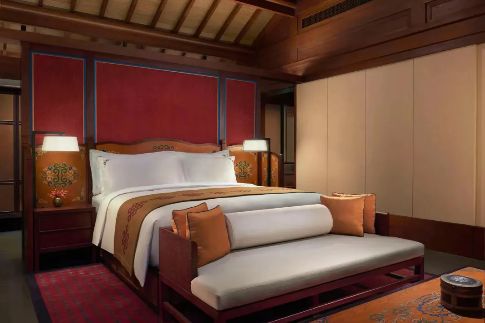 Villa bedroom with red lacquered headboard at Rissai Valley