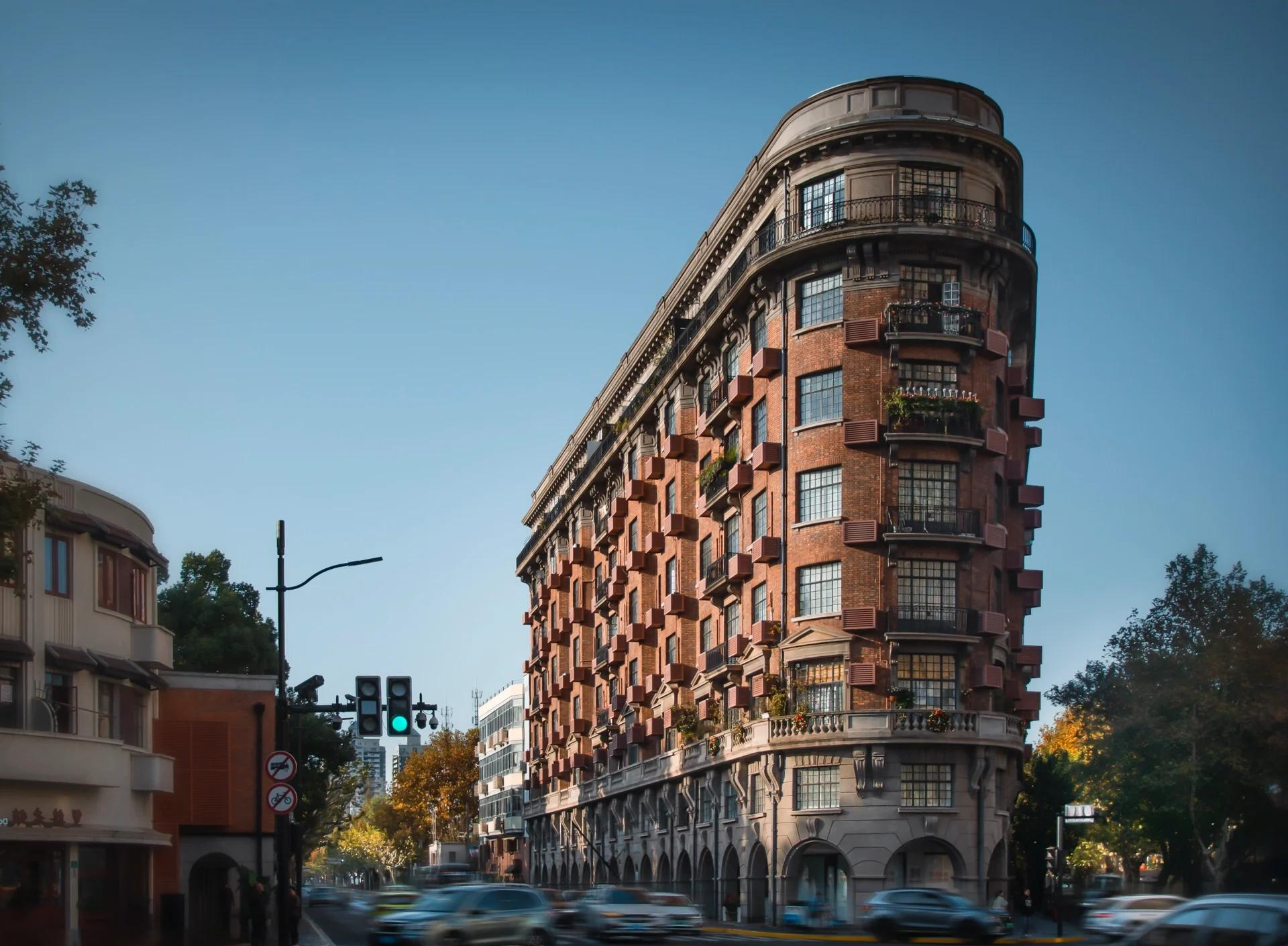 The red-brick Wukang Mansion on a tree-lined Shanghai street