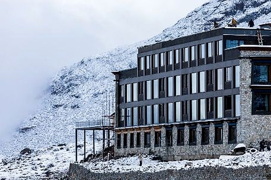Lodge exterior in falling snow at Songtsam Lodge Laigu