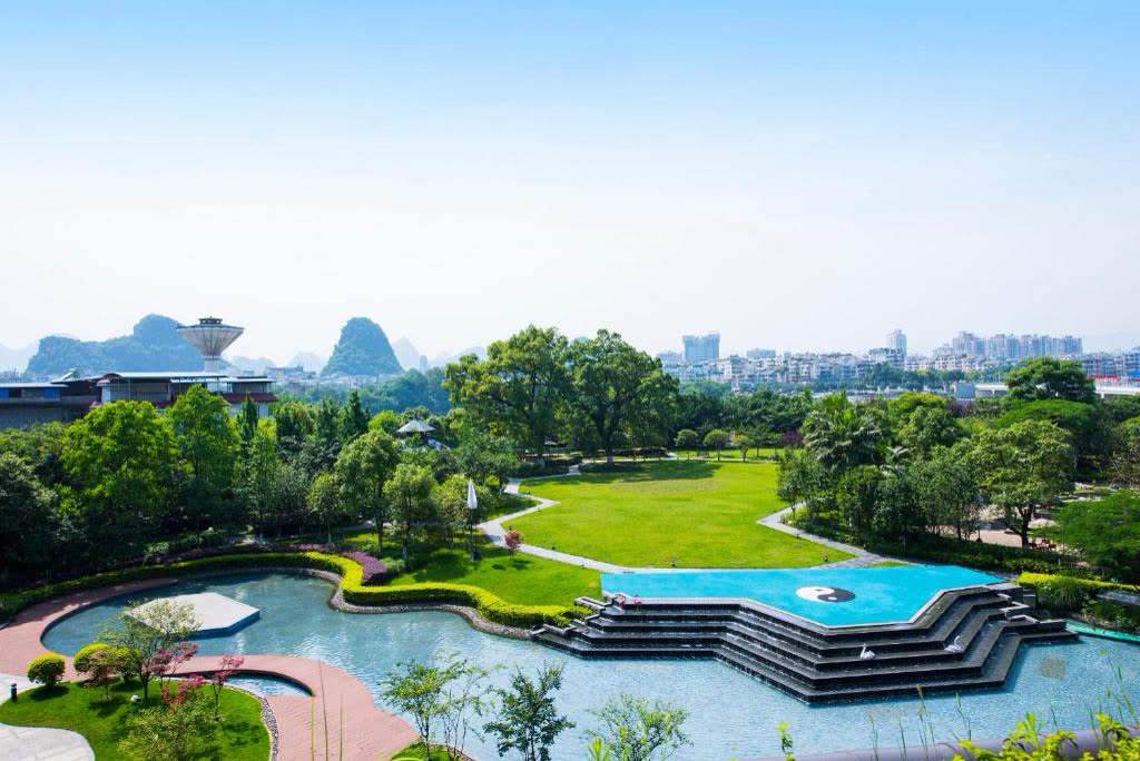 Terraced water gardens and lawns at Shangri-La Guilin with karst peaks beyond