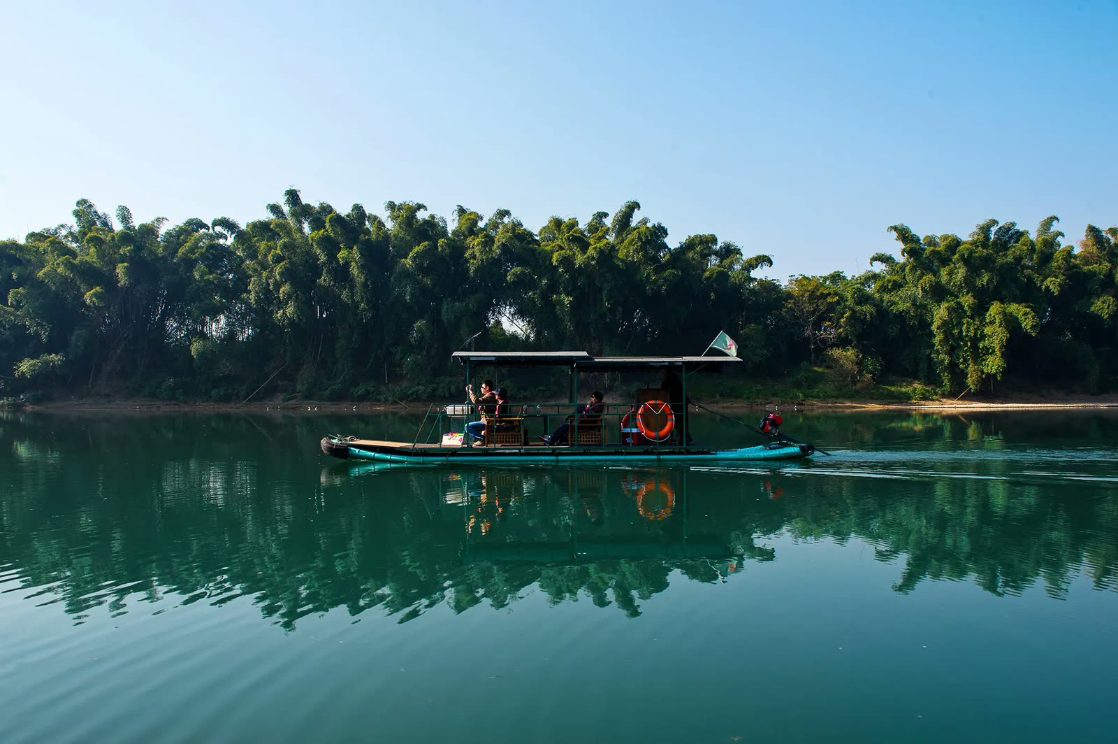 Bamboo raft drifting past bamboo groves on the Yulong River near Banyan Tree Yangshuo