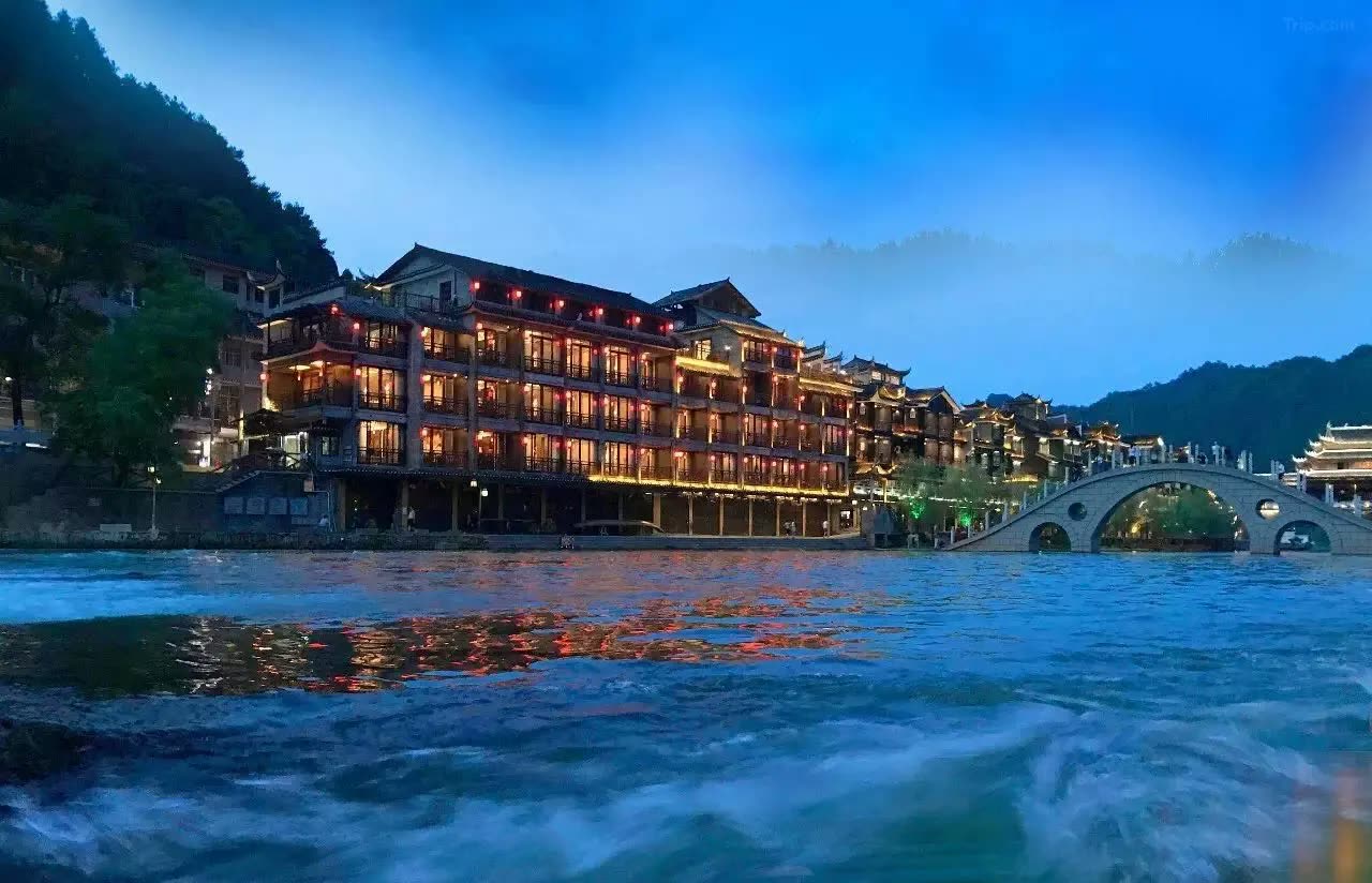 Sulv Lianhua Hotel lit up on the Tuo River at dusk