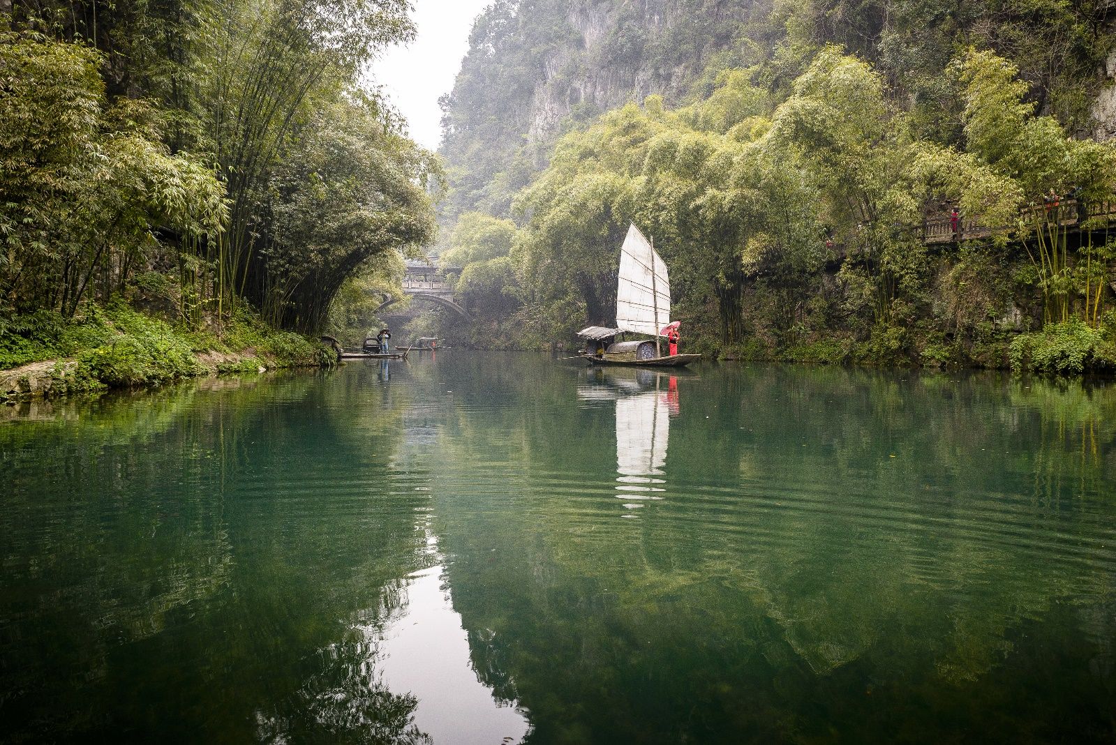 Traditional sailing junk on the emerald waters of a Yangtze tributary gorge