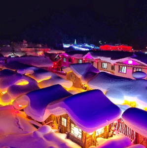 Snow Town cottages under deep snow, glowing with lantern light at night