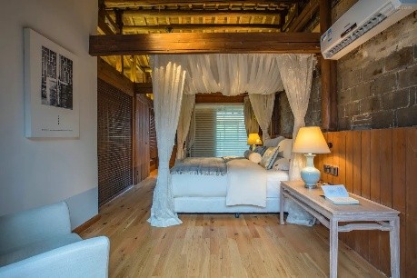 A canopy bed inside a timbered Classic Room at Wuyuan Skywells
