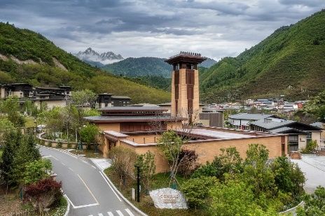 Conrad Jiuzhaigou resort building with mountain backdrop