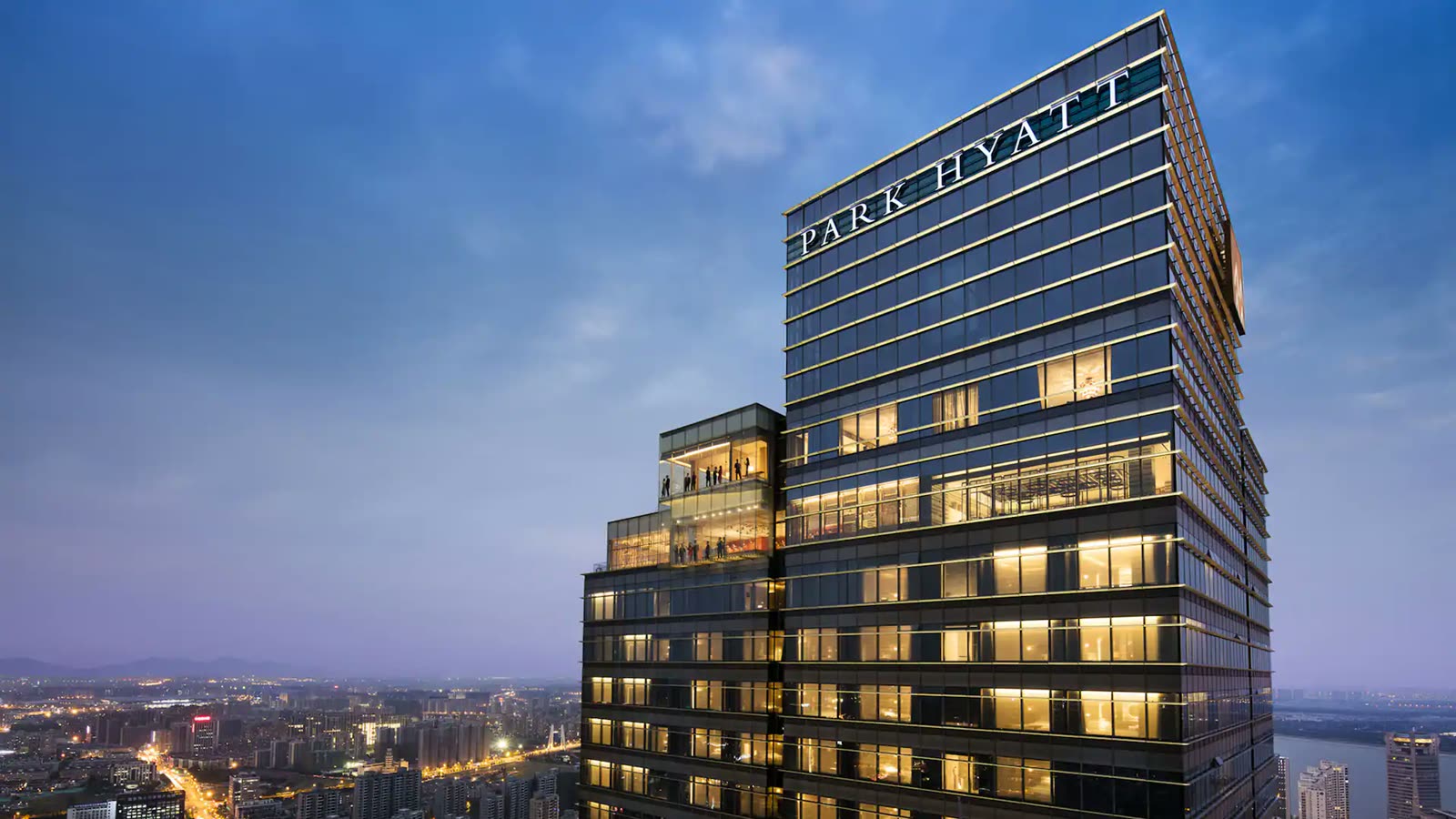 Park Hyatt Hangzhou tower lit at dusk above the city