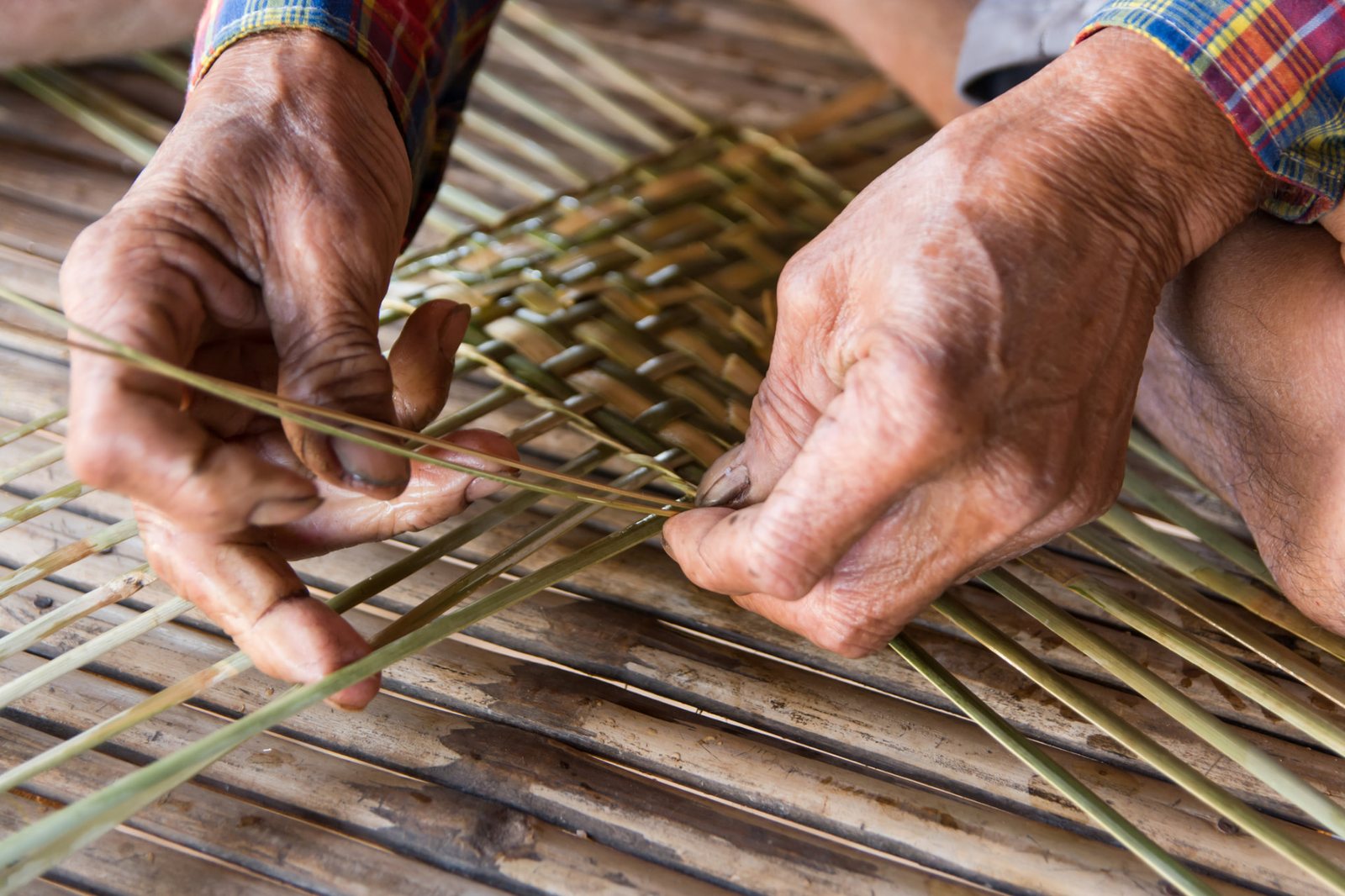 A village craftsman weaving bamboo strips by hand
