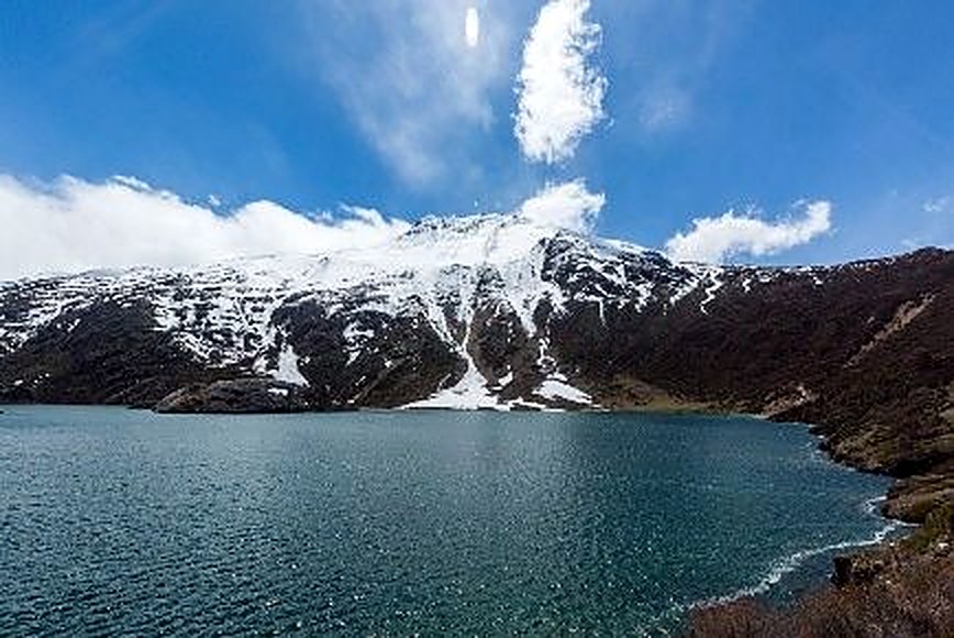 Snow-capped peak reflected in the still waters near Rawu