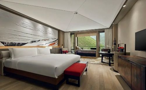 Deluxe guest room at Conrad Jiuzhaigou with mountain artwork