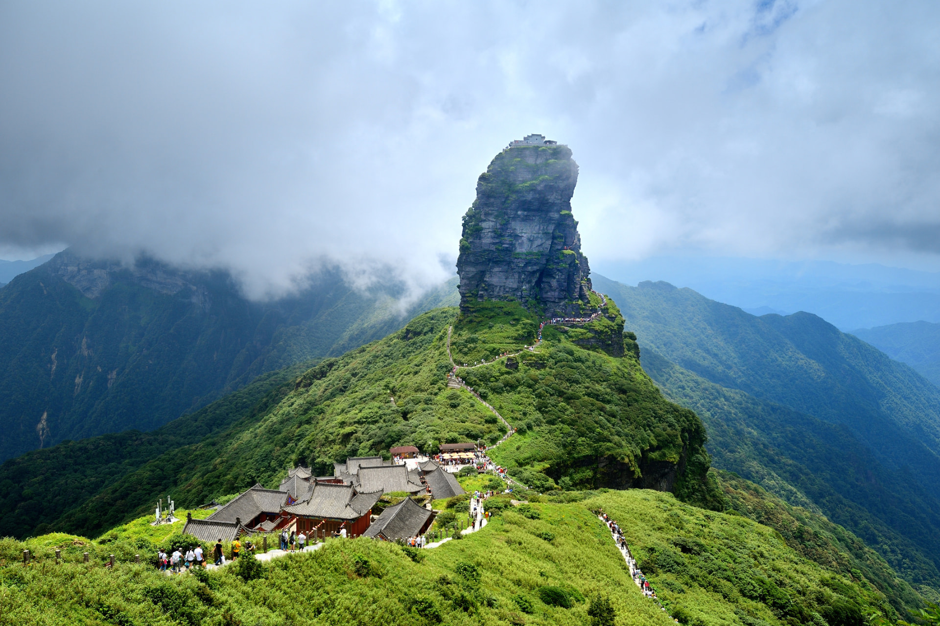 Mount Fanjing rising above green mountain ridges and clouds