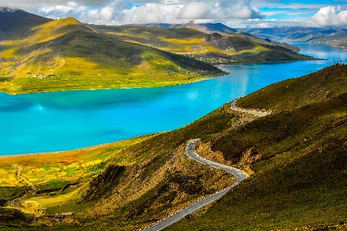 The turquoise waters of Yamdrok Lake beside the mountain road