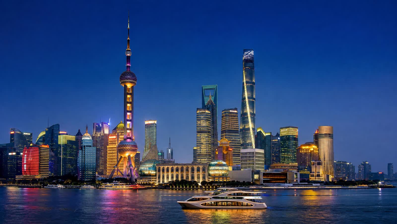 Shanghai Pudong skyline at blue hour, with the Oriental Pearl Tower and Shanghai Tower reflected on the Huangpu River